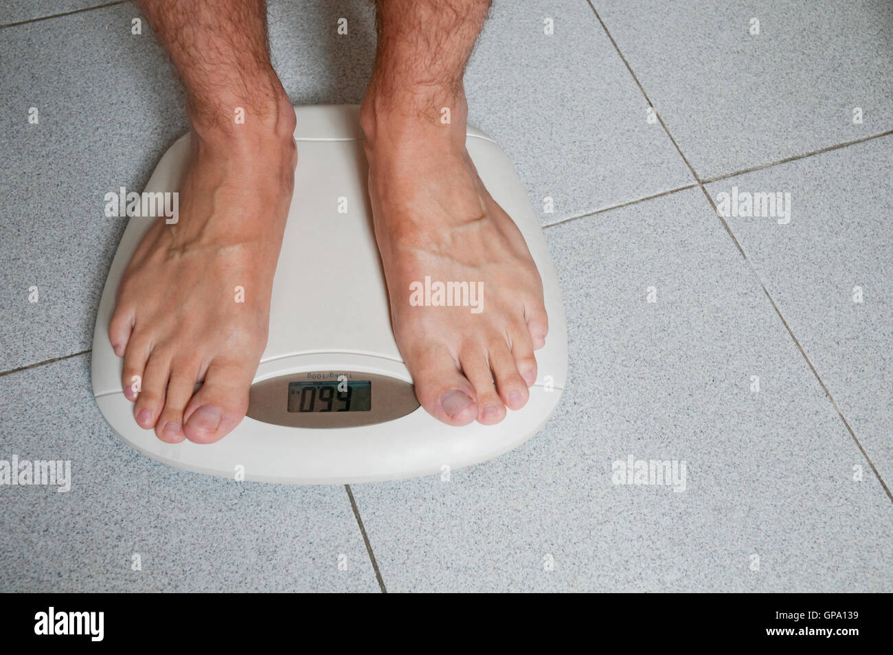 Mature man weighing himself. Stock Photo