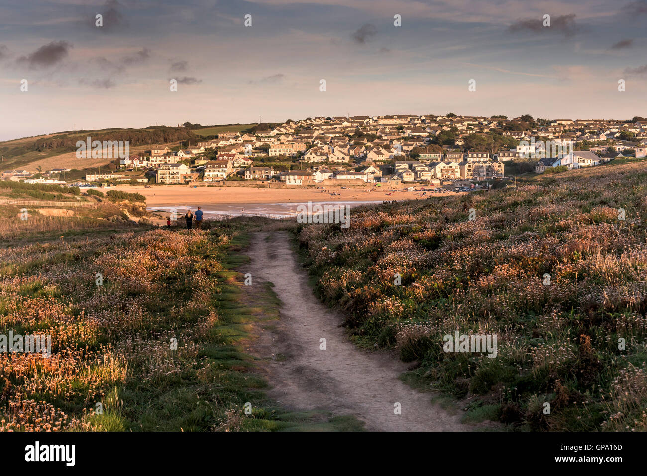 A footpath on Porth Island with coastal property in the distance. Newquay. Cornwall. Stock Photo