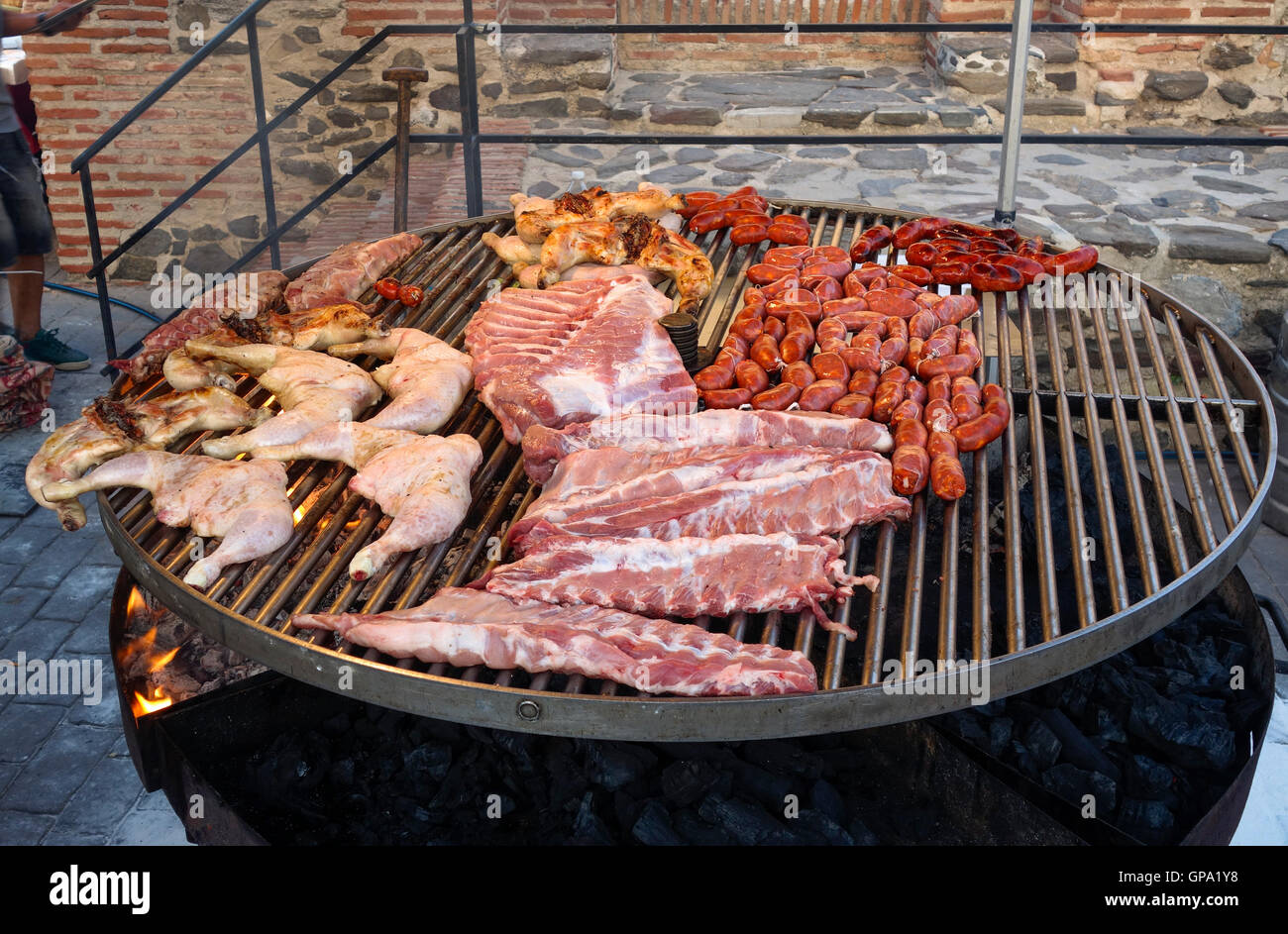 Chicken legs, ribs, chorizo, sausages, on an outdoor barbecue Grill