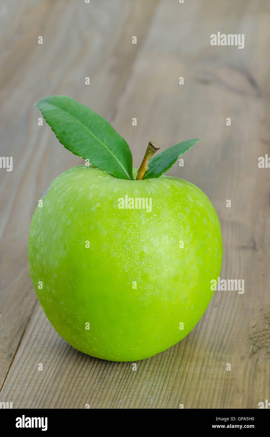 Ripe green apple with leaf  on a wooden background Stock Photo