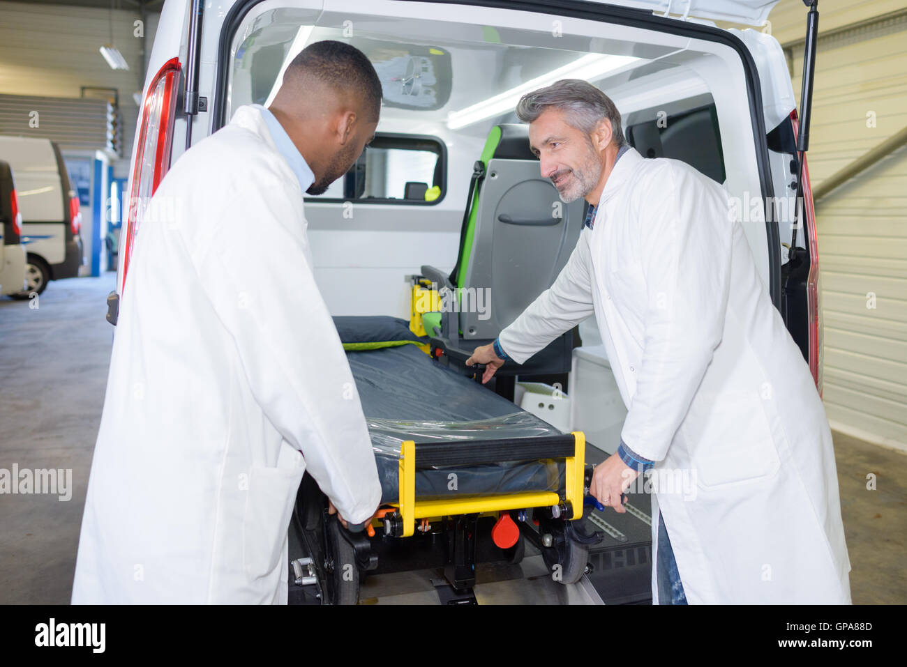 Paramedics loading stretcher into ambulance Stock Photo Alamy