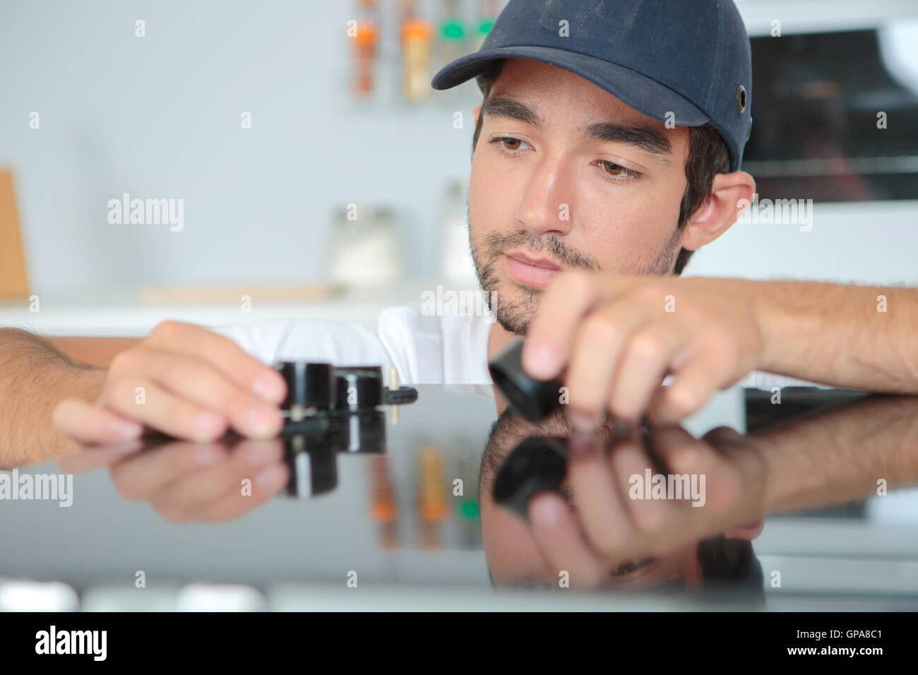 Man fitting knobs to kitchen hob Stock Photo Alamy