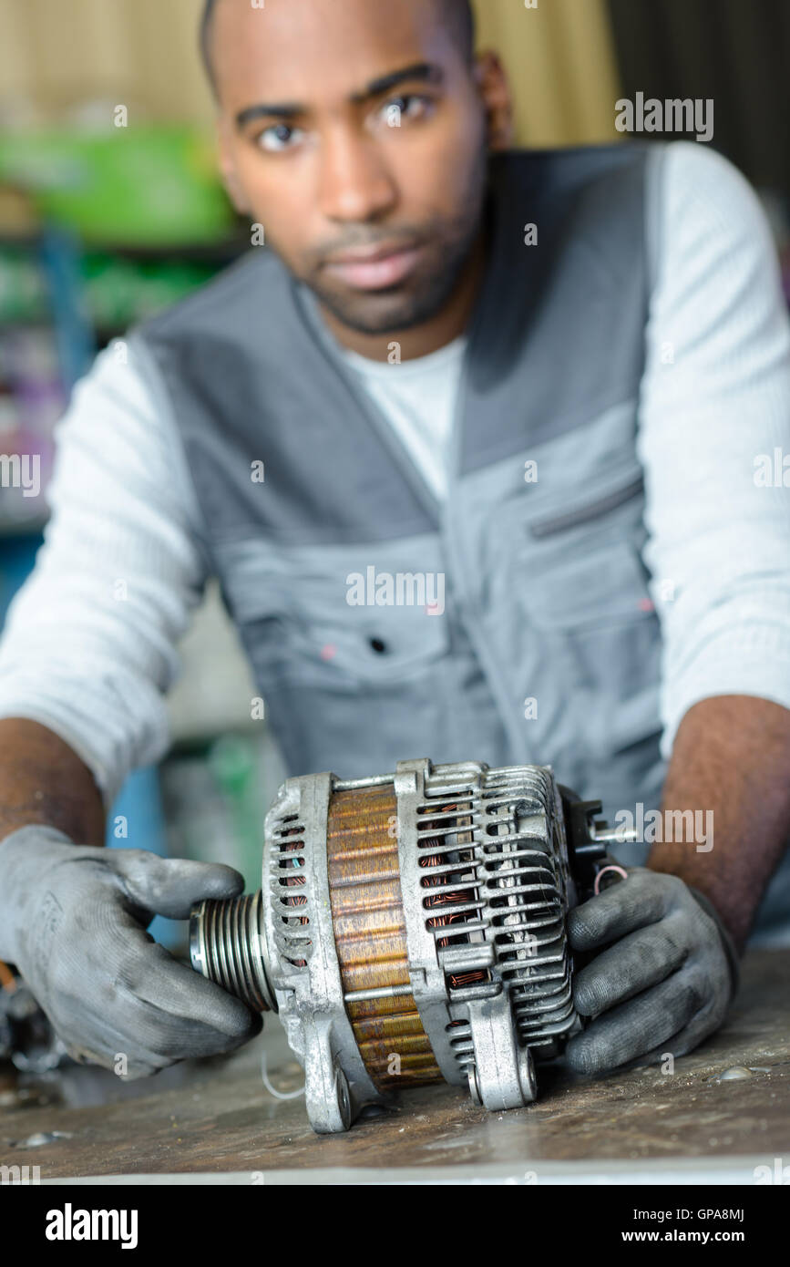 Mechanic holding engine component Stock Photo Alamy
