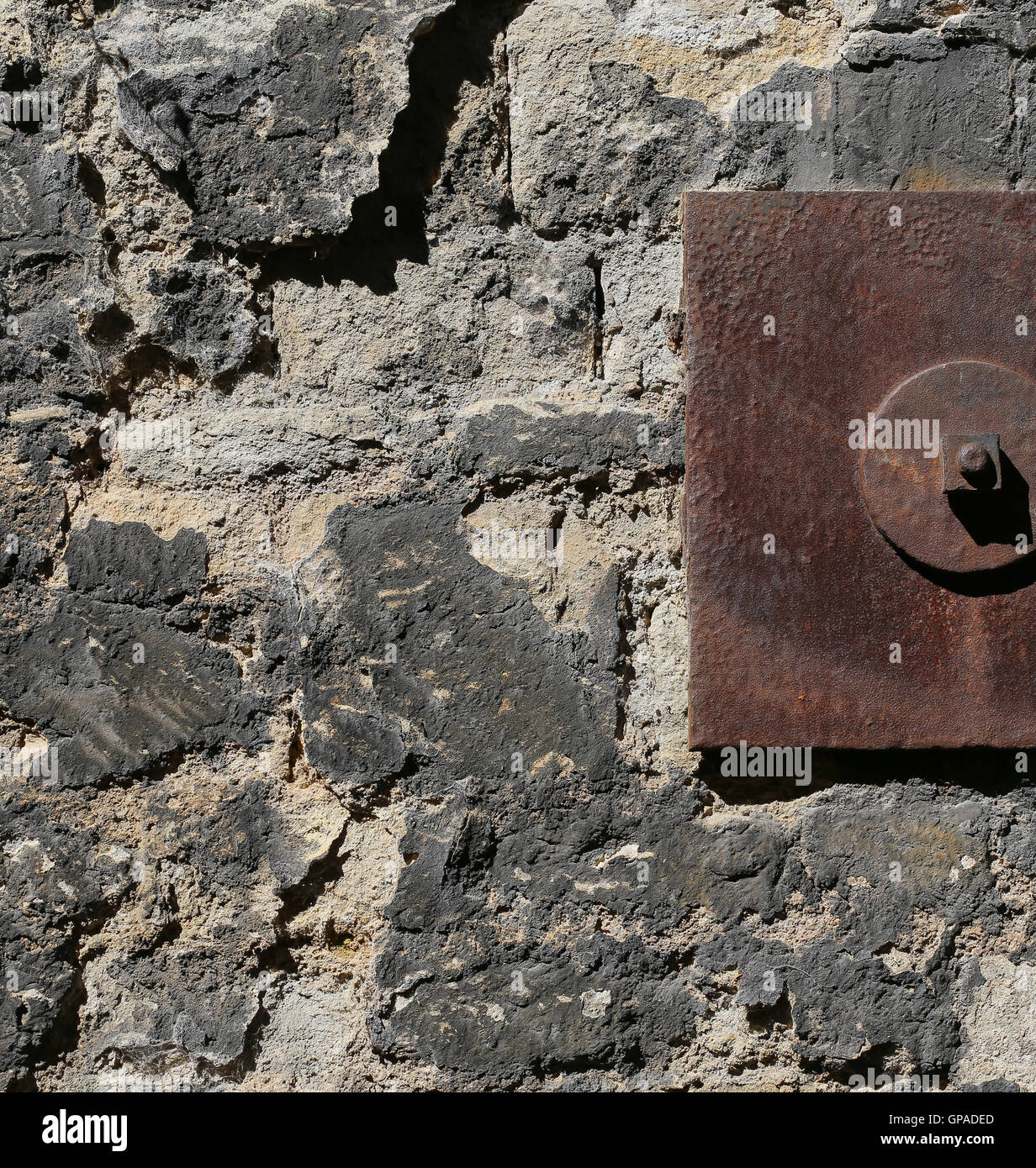 Old stone wall reinforced with metal plates closeup architectural detail background Stock Photo