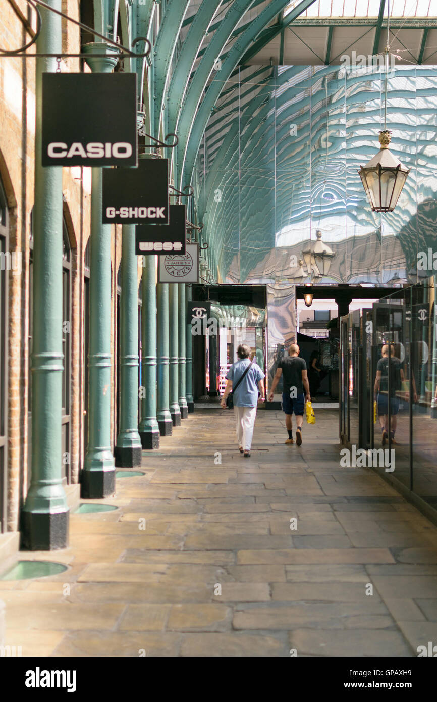London, England - 30 August 2016: People walk in Covent Market halls. The central hall has shops, cafes and bars. Stock Photo