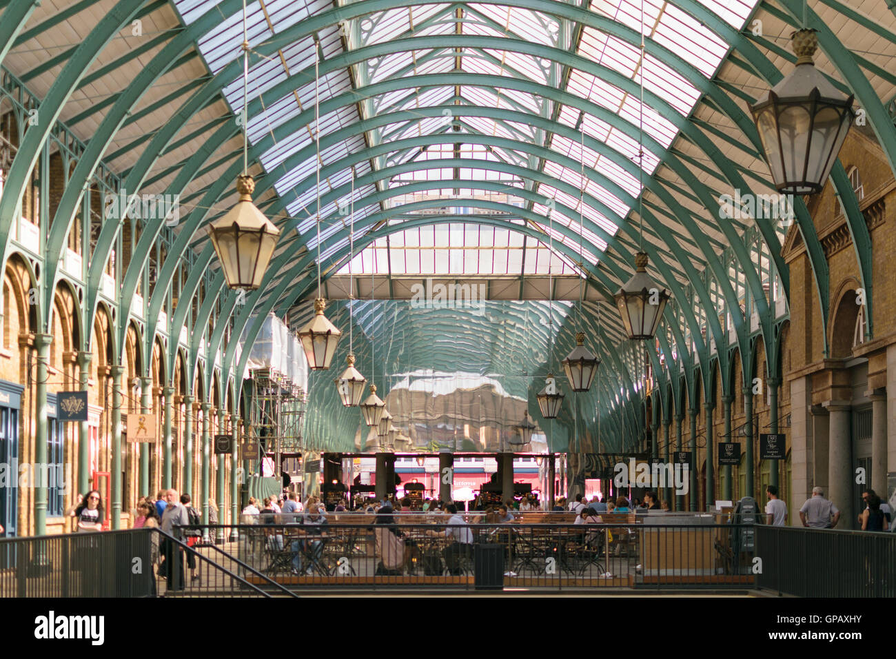 London, England - 30 August 2016: People spend time in Covent Market halls. The central hall has shops, cafes and bars. Stock Photo