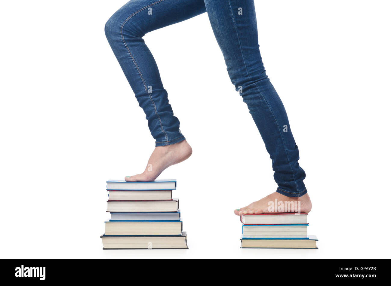 Student sitting on stack of books Stock Photo - Alamy