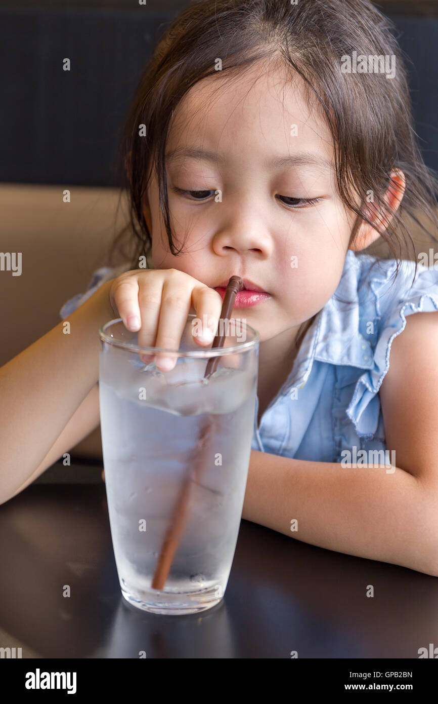 Child using straw to drink cold water from glass Stock Photo Alamy