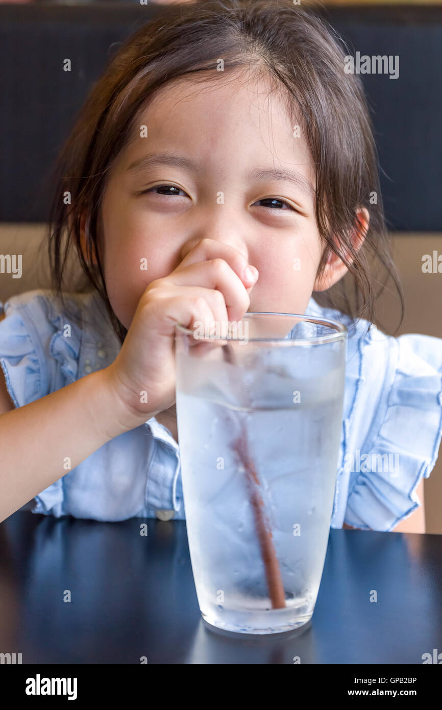 Child drinking water from glass using straw Stock Photo Alamy