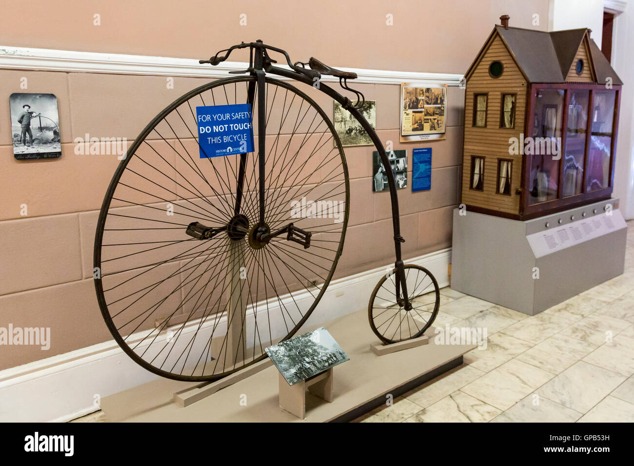 Fort Wayne, Indiana - A penny-farthing bicycle and dollhouse on display at the History Center museum. Stock Photo