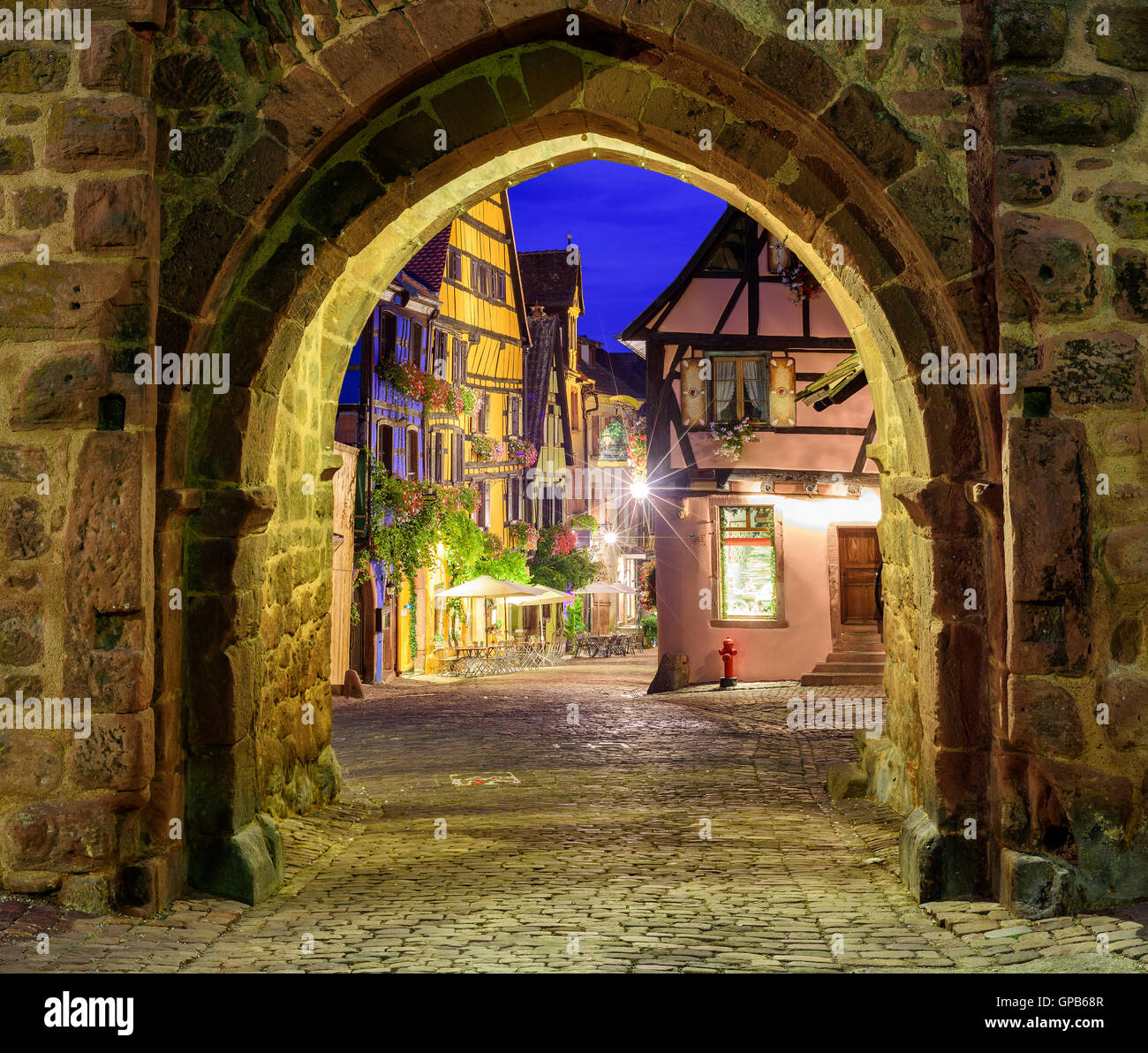 View of Riquewihr, Alsace, France, through city wall gate at night Stock Photo