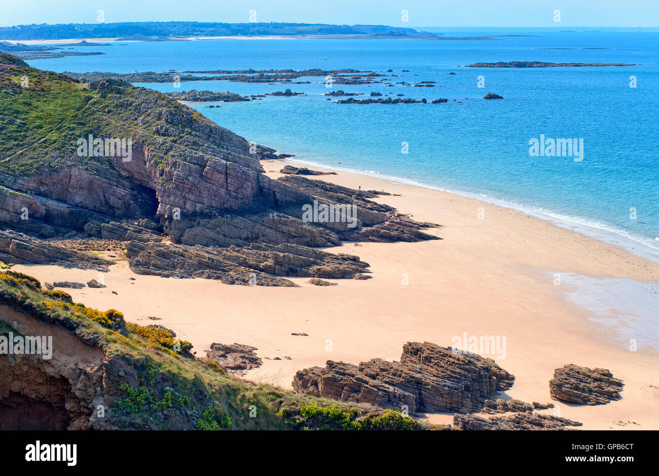 Dark rocks on a sand beach at atlantic coast Cote de Granite Rose in Brittany, France Stock Photo