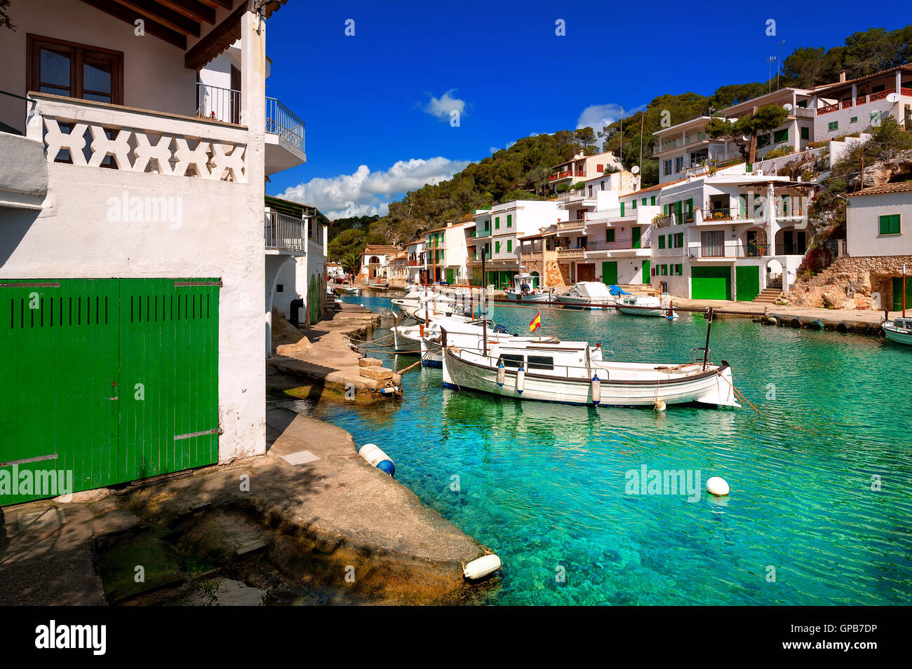 White villas and boats on green water in picturesque fishermen village Cala Figuera, Mediterranean Sea, Mallorca, Spain Stock Photo