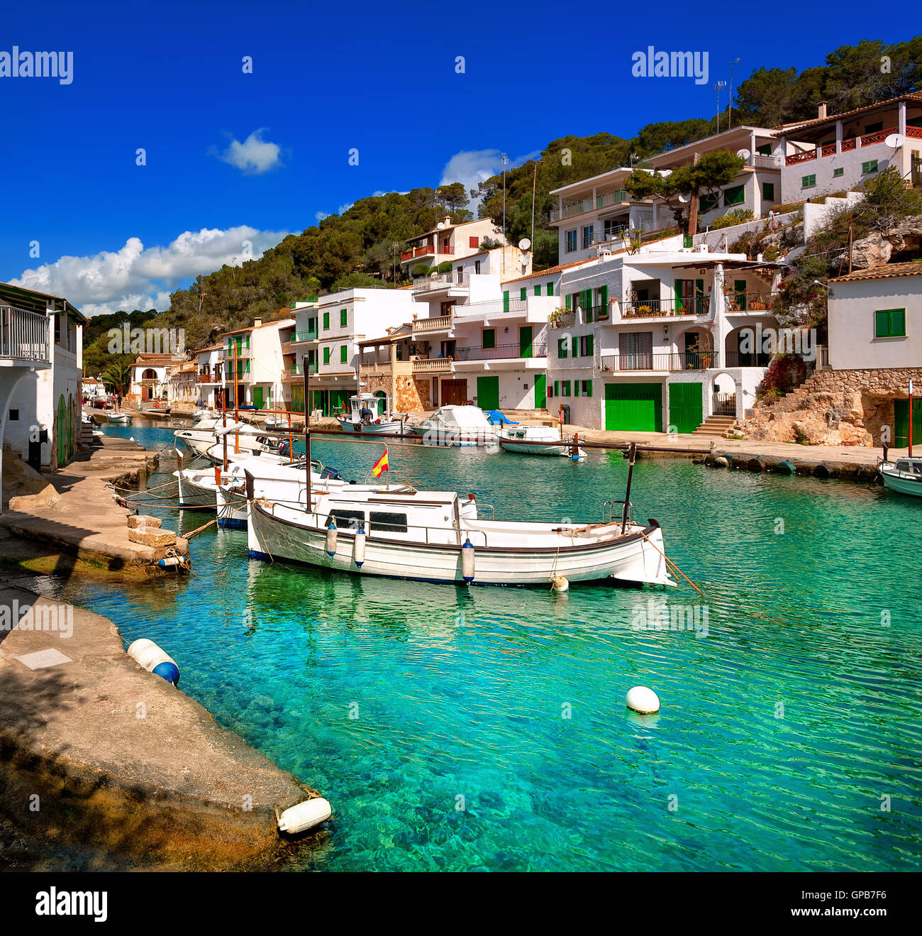 White villas and boats on green water in picturesque fishermen village Cala Figuera, Mediterranean Sea, Mallorca, Spain Stock Photo