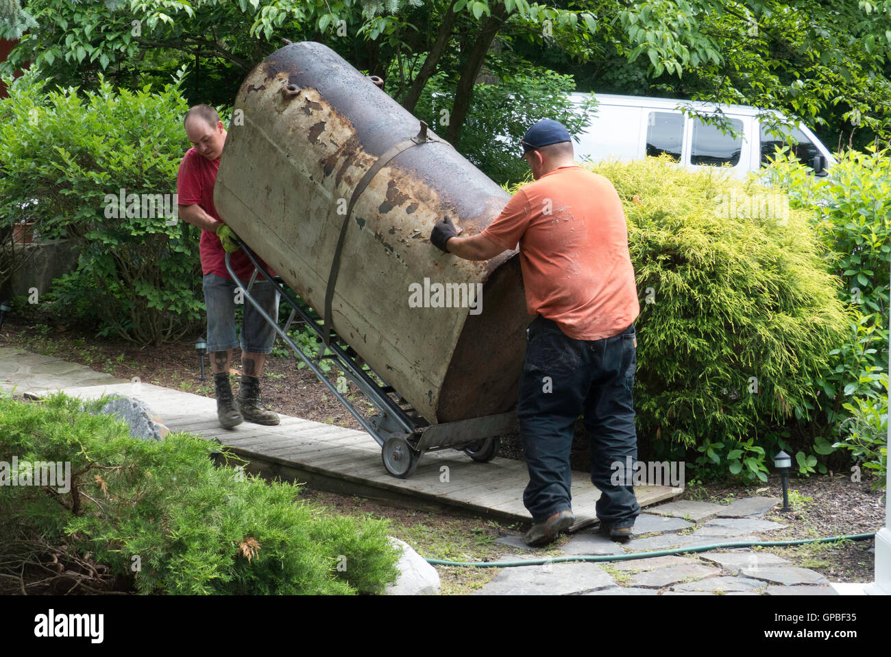 men moving oil tank from home,New York State Stock Photo Alamy