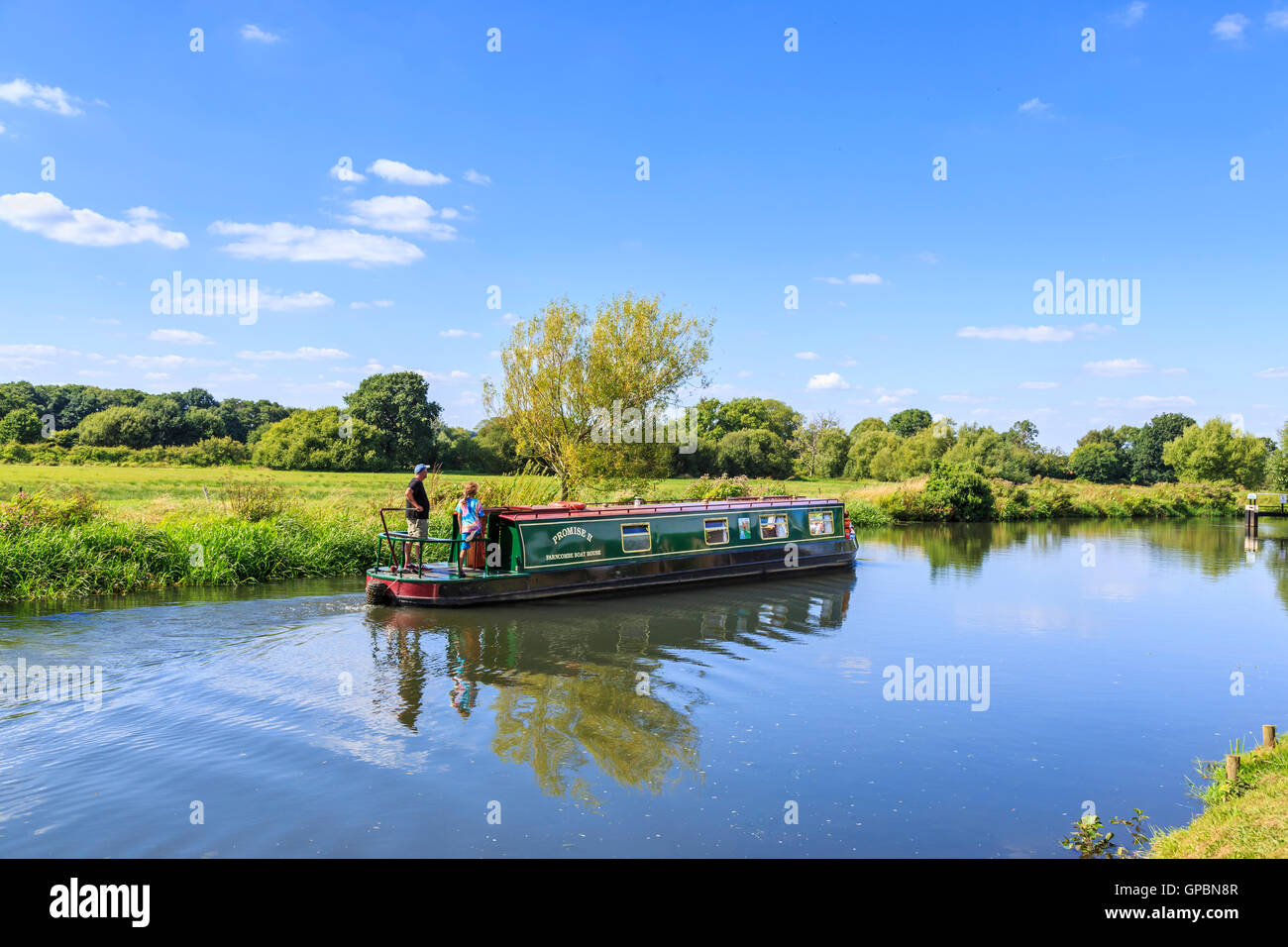 Narrowboat cruising on the Wey Navigation at Worsfold Gates near Send, Surrey in summer on a sunny day with blue sky Stock Photo