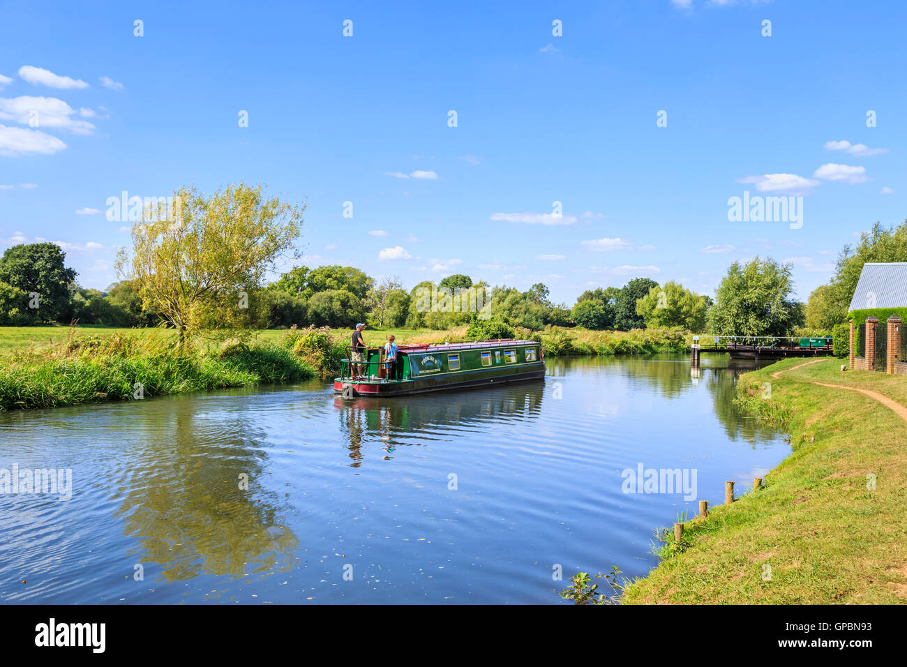Narrowboat cruising on the Wey Navigation at Worsfold Gates near Send, Surrey in summer on a sunny day with blue sky Stock Photo