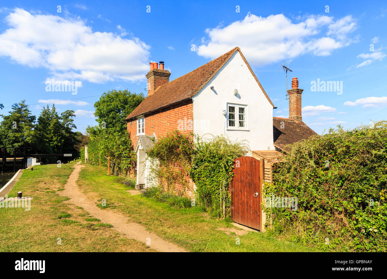 Cottage on the towpath at Triggs Lock, Wey Navigation, near Send, Surrey in summer with blue sky