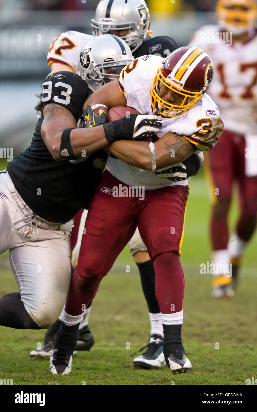 December 13, 2009; Oakland, CA, USA;  Washington Redskins running back Marcus Mason (32) is tackled by Oakland Raiders defensive end Tommy Kelly (93) during the third quarter at Oakland-Alameda County Coliseum.  Washington defeated Oakland 34-13. Stock Photo