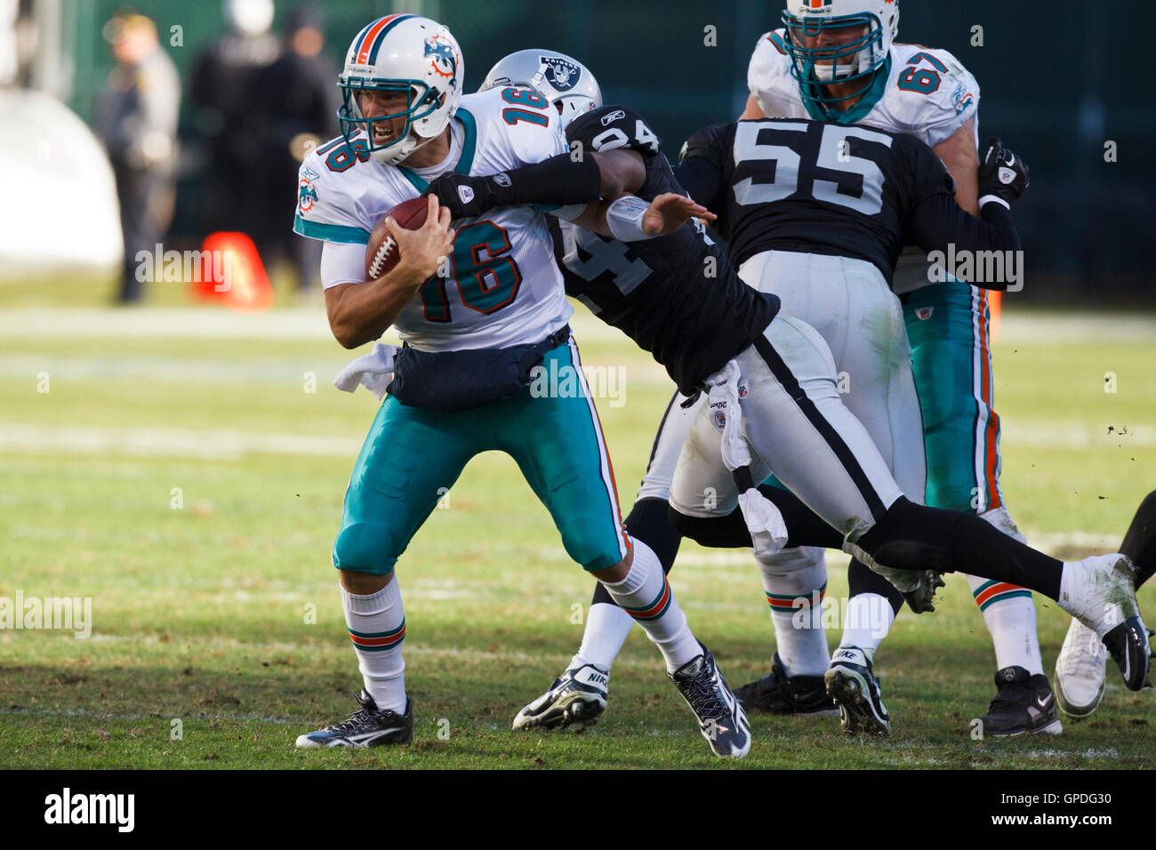 November 28, 2010; Oakland, CA, USA;  Miami Dolphins quarterback Tyler Thigpen (16) is tackled by Oakland Raiders safety Michael Huff (24) during the third quarter at Oakland-Alameda County Coliseum. Miami defeated Oakland 33-17. Stock Photo