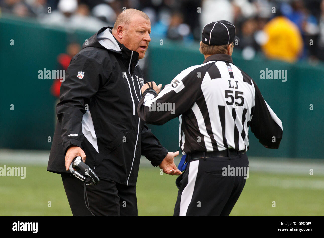 December 19, 2010; Oakland, CA, USA;  Oakland Raiders head coach Tom Cable argues a call with line judge Tom Barnes (55) during the second quarter against the Denver Broncos at Oakland-Alameda County Coliseum. Stock Photo