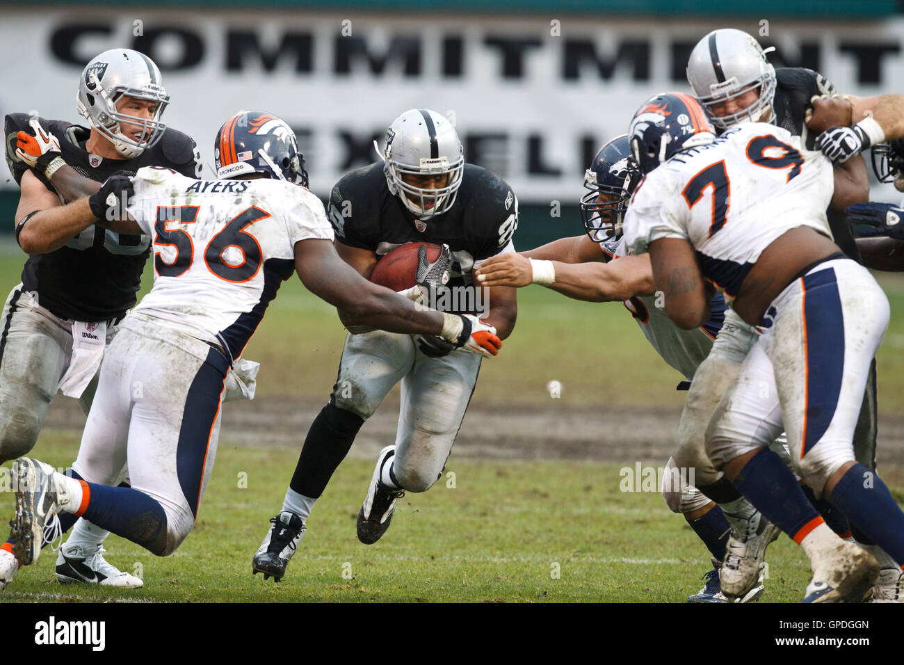 December 19, 2010; Oakland, CA, USA;  Oakland Raiders running back Michael Bush (29) is tackled by Denver Broncos linebacker Robert Ayers (56) during the third quarter at Oakland-Alameda County Coliseum. Oakland defeated Denver 39-23. Stock Photo