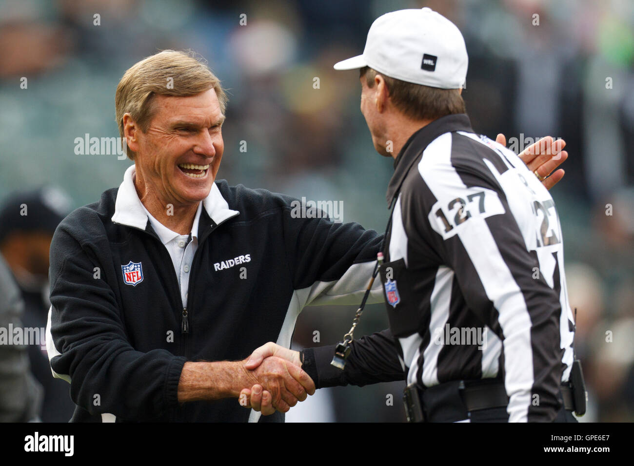 Dec 18, 2011; Oakland, CA, USA; Oakland Raiders offensive coordinator Al Saunders (left) shakes hands with NFL referee Bill Leavy (127) before the game against the Detroit Lions at O.co Coliseum. Detroit defeated Oakland 28-27. Stock Photo