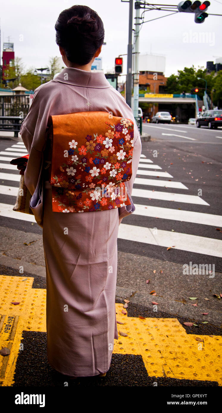A woman in a kimono waits at a zebra crossing in Tokyo, Japan Stock ...