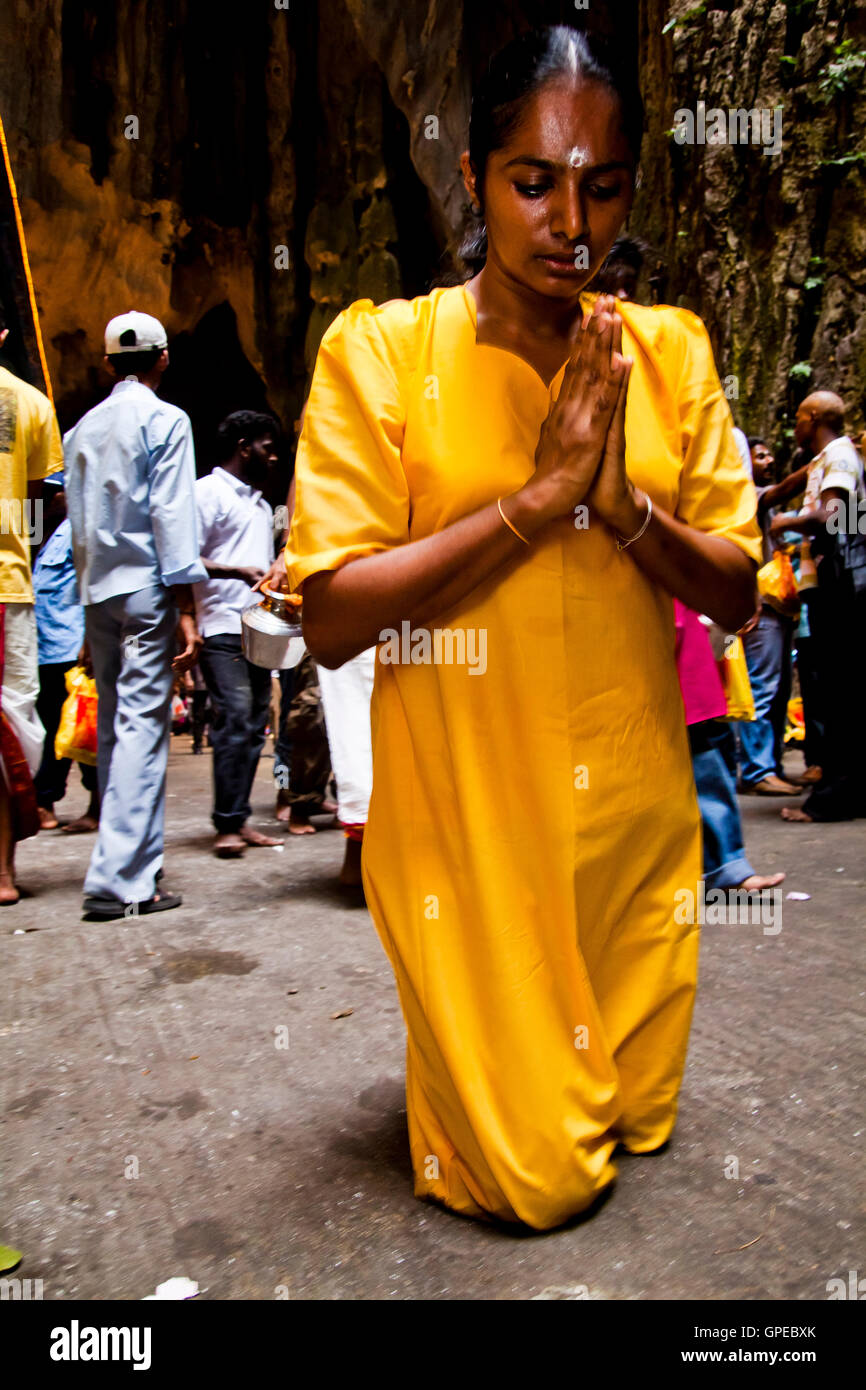 A woman prays on her knees at the Thaipusam festival, Batu Caves, Malaysia. Stock Photo