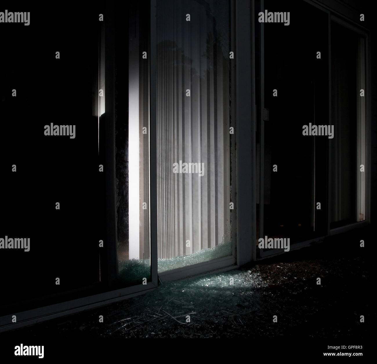 House with a shattered sliding glass door and flashlight on inside Stock Photo Alamy