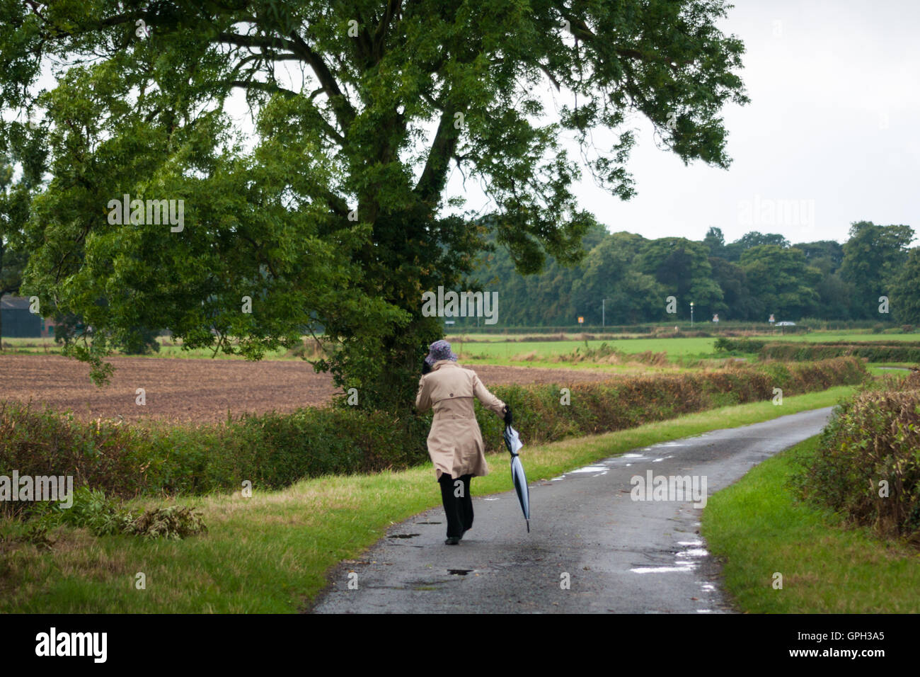 Woman walking down country lane hi-res stock photography and images - Alamy