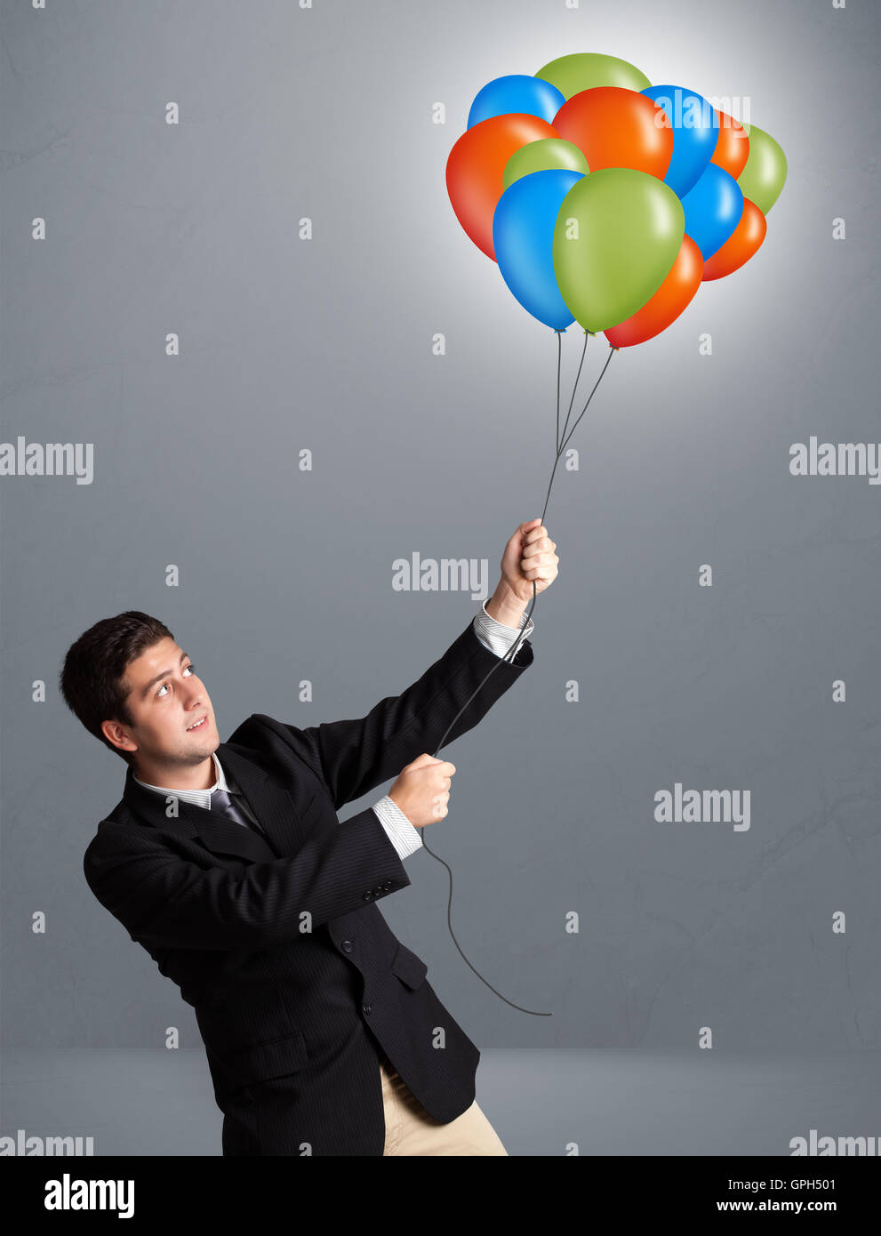 Handsome man holding colorful balloons Stock Photo - Alamy