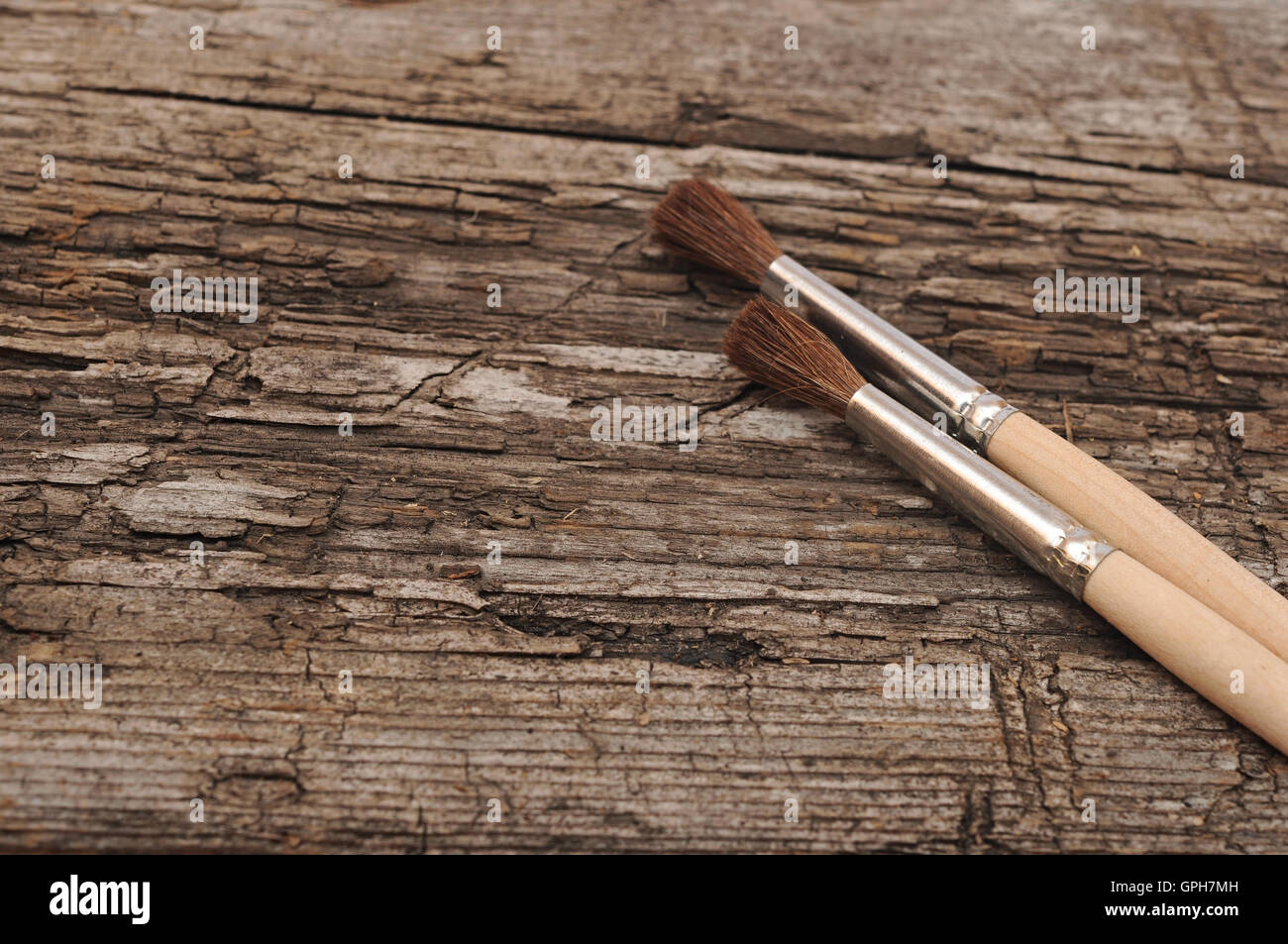 paintbrushes on very old wooden desk Stock Photo