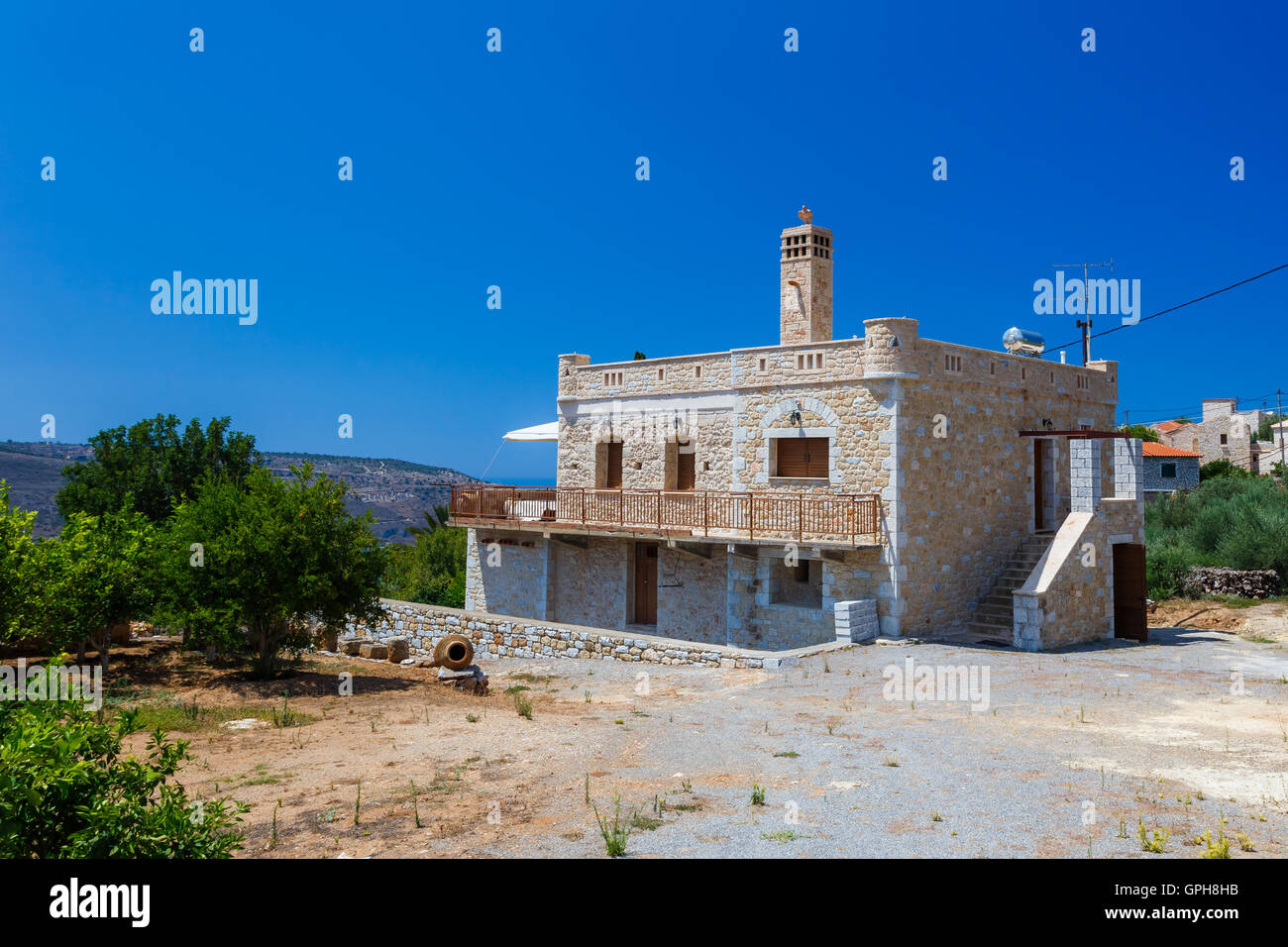 Traditional style built house in Itilo village against a blue sky and clouds in Mani, Laconia, Greece Stock Photo