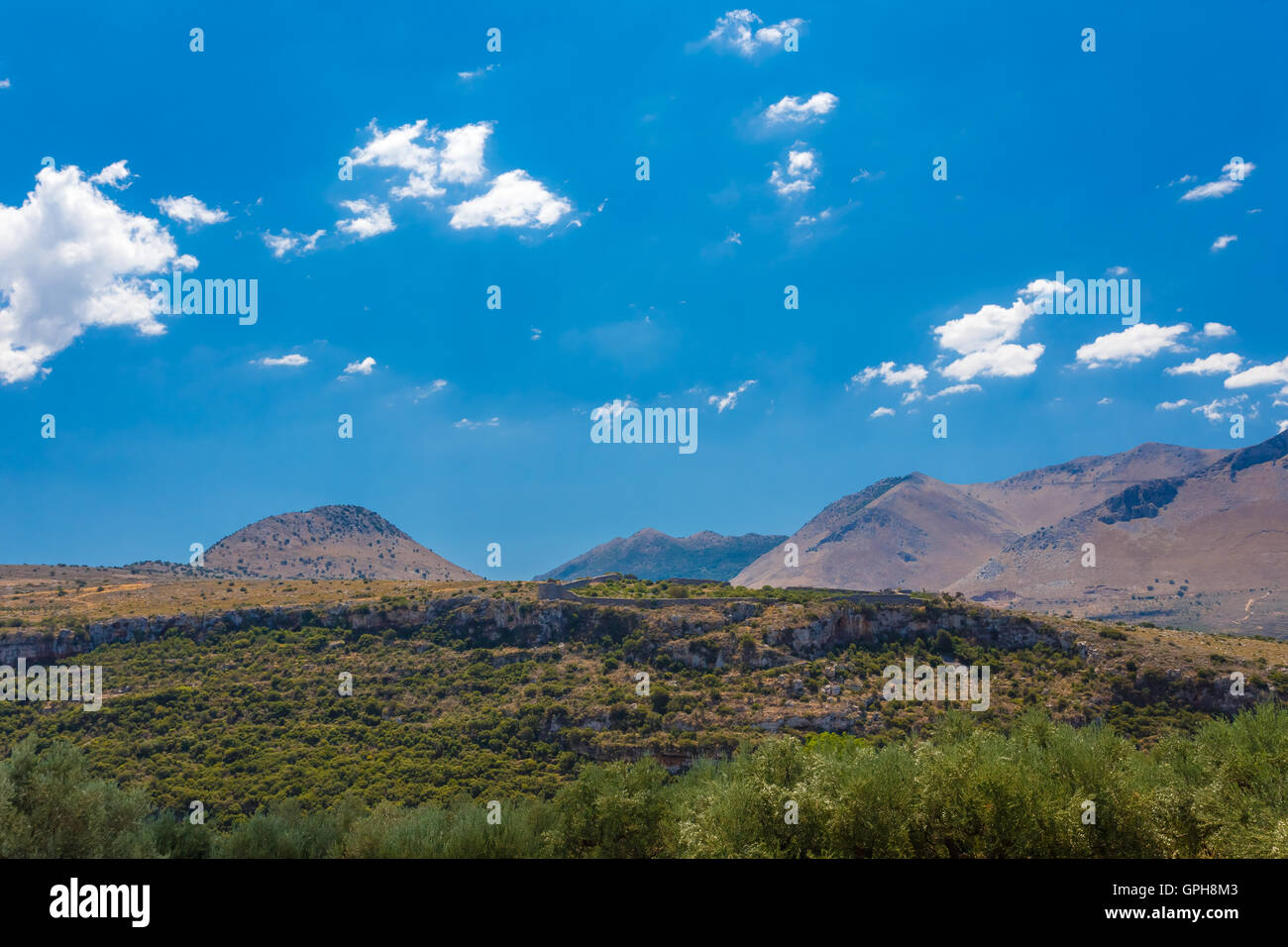 The Castle of Kelefa against the Taygetos mountains covered in green trees against a partly cloudy sky Stock Photo