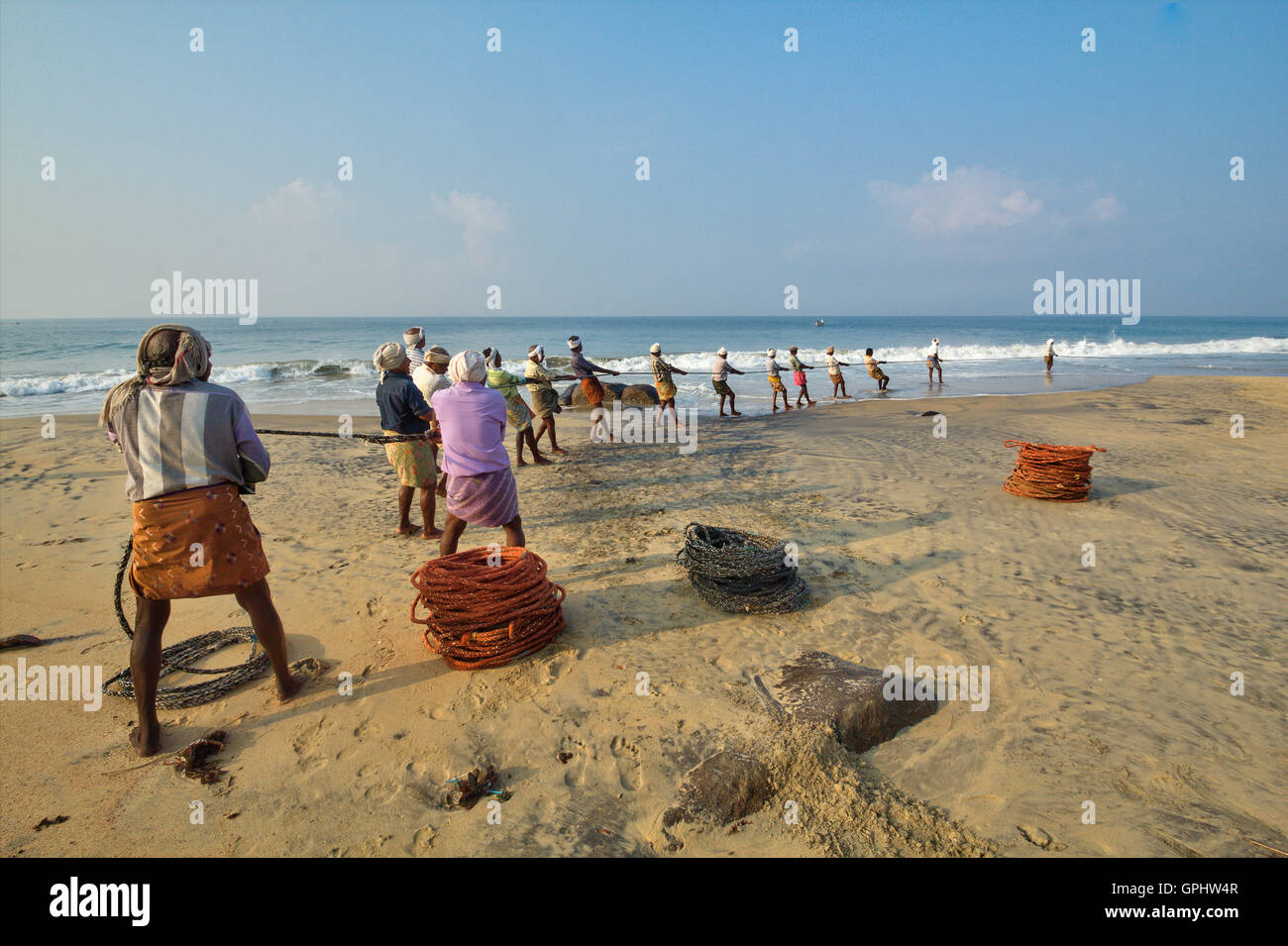 Fishermen hauling in nets at sunrise, Vizhinjam Beach, Kovalam, Kerala,India, Asia Stock Photo