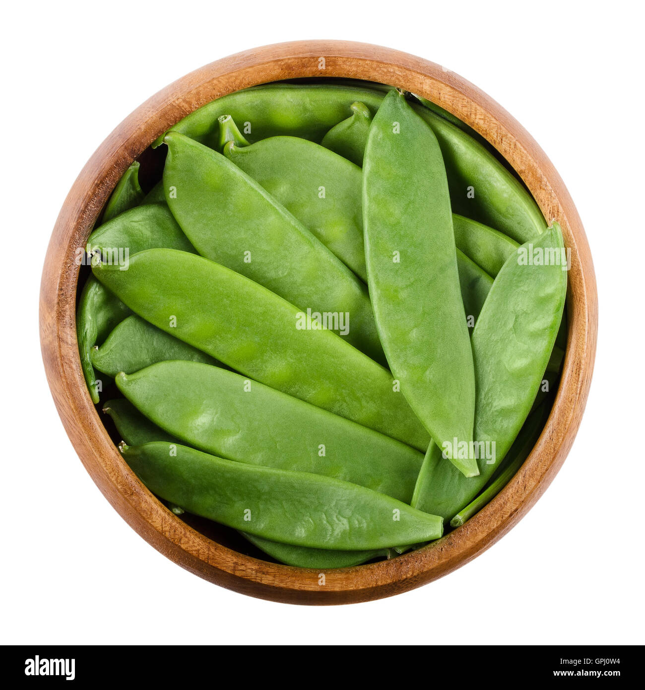Snow peas in a wooden bowl on white background. Pisum sativum saccharatum, a green legume and variety of pea, eaten whole. Stock Photo
