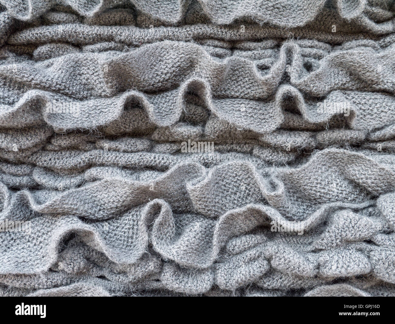 Dark gray ruched knitted wool fabric cool weather background Stock Photo