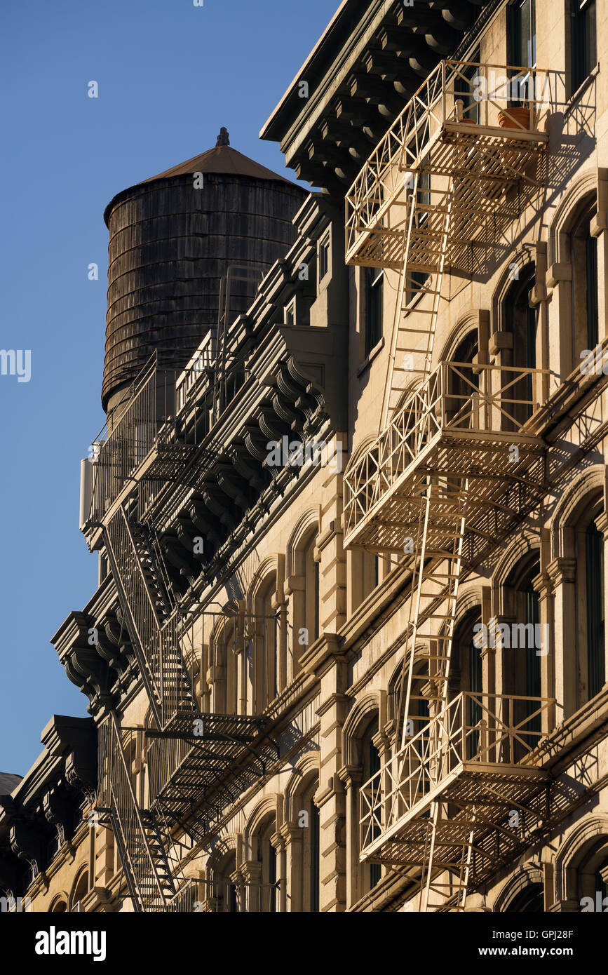 Soho buildings facades with fire escape and wooden water tower. Manhattan, New York City Stock Photo