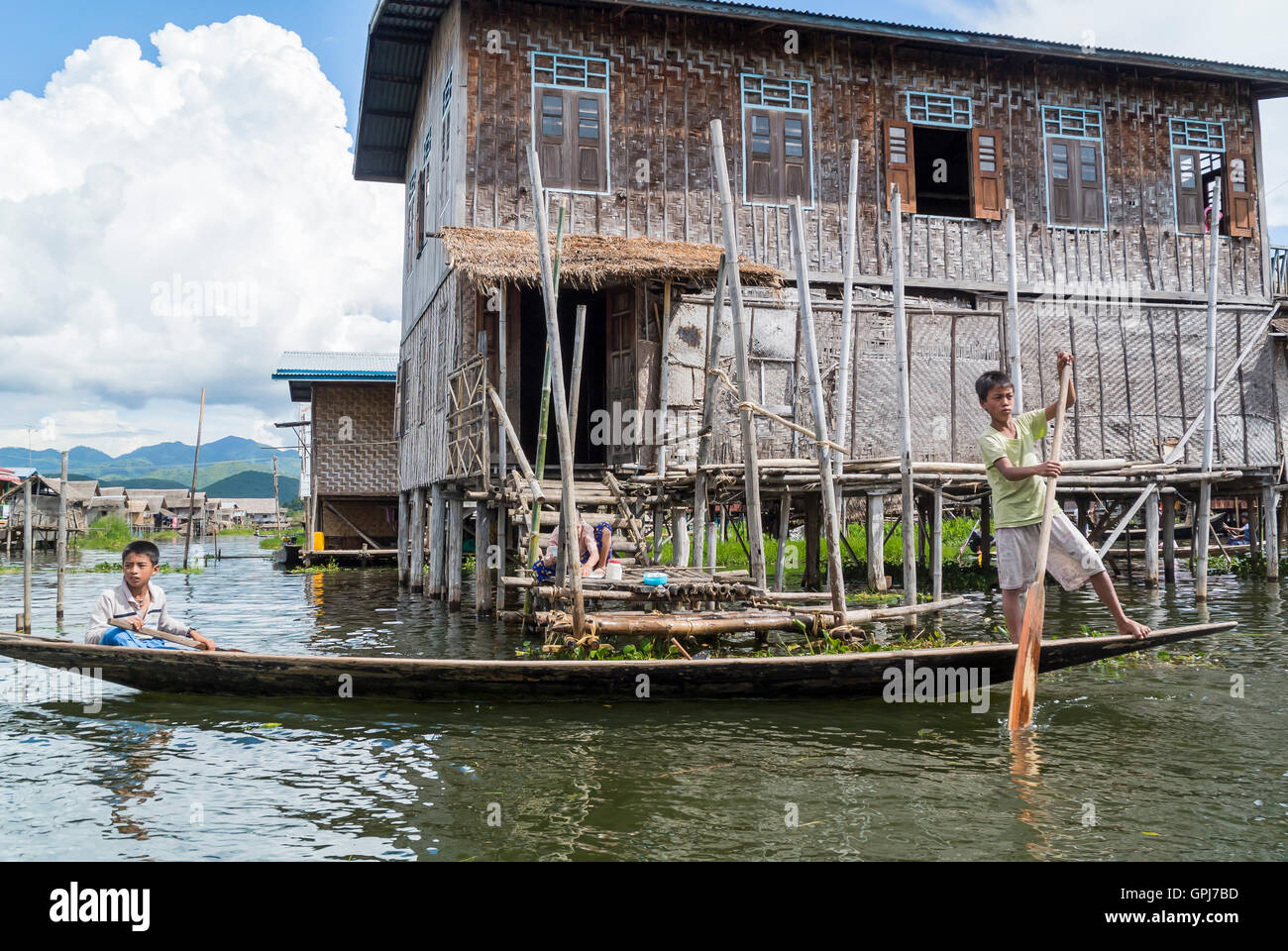 Boys on Long Banana Shaped Boat, Inle Lake, Myanmar Stock Photo