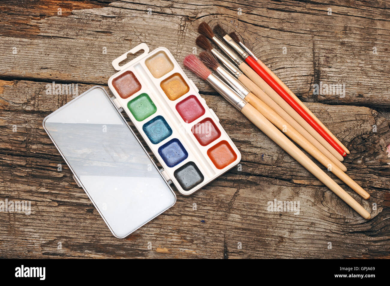 paints and brushes on old wooden table Stock Photo