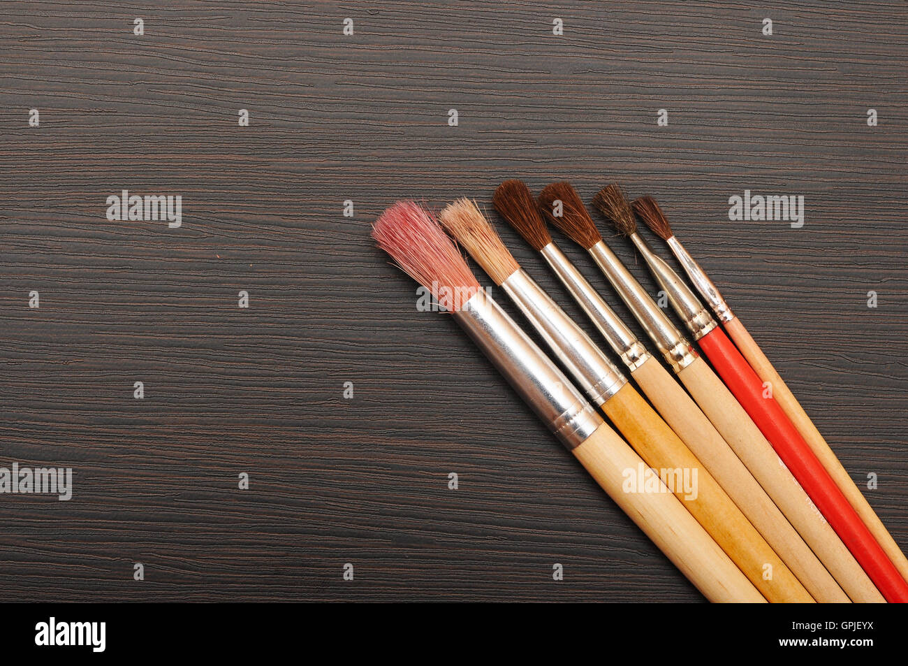 Paint brushes on dark wooden background Stock Photo