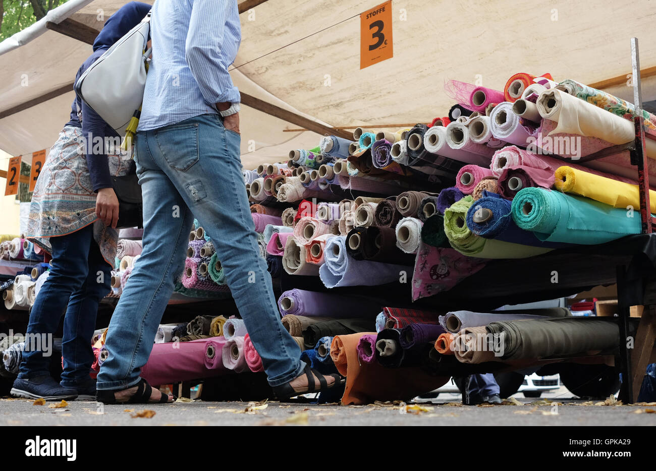 A trader offering different fabrics at the fabric market at Maybachufer