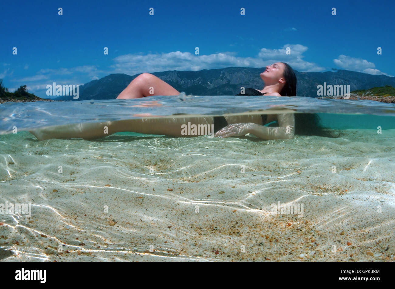 March 3, 2016 - Split level, woman tanning lying in water, leopatra island (Sedir Island), Aegean Sea, Turkey © Andrey Nekrasov/ZUMA Wire/ZUMAPRESS.com/Alamy Live News Stock Photo
