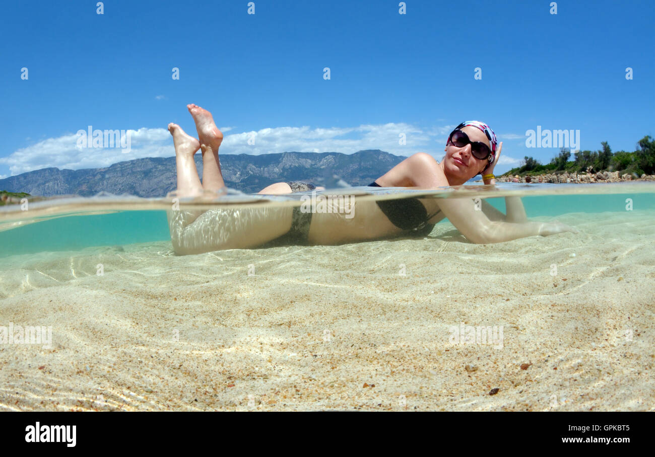 March 3, 2016 - Split level, woman tanning lying in water, leopatra island (Sedir Island), Aegean Sea, Turkey © Andrey Nekrasov/ZUMA Wire/ZUMAPRESS.com/Alamy Live News Stock Photo