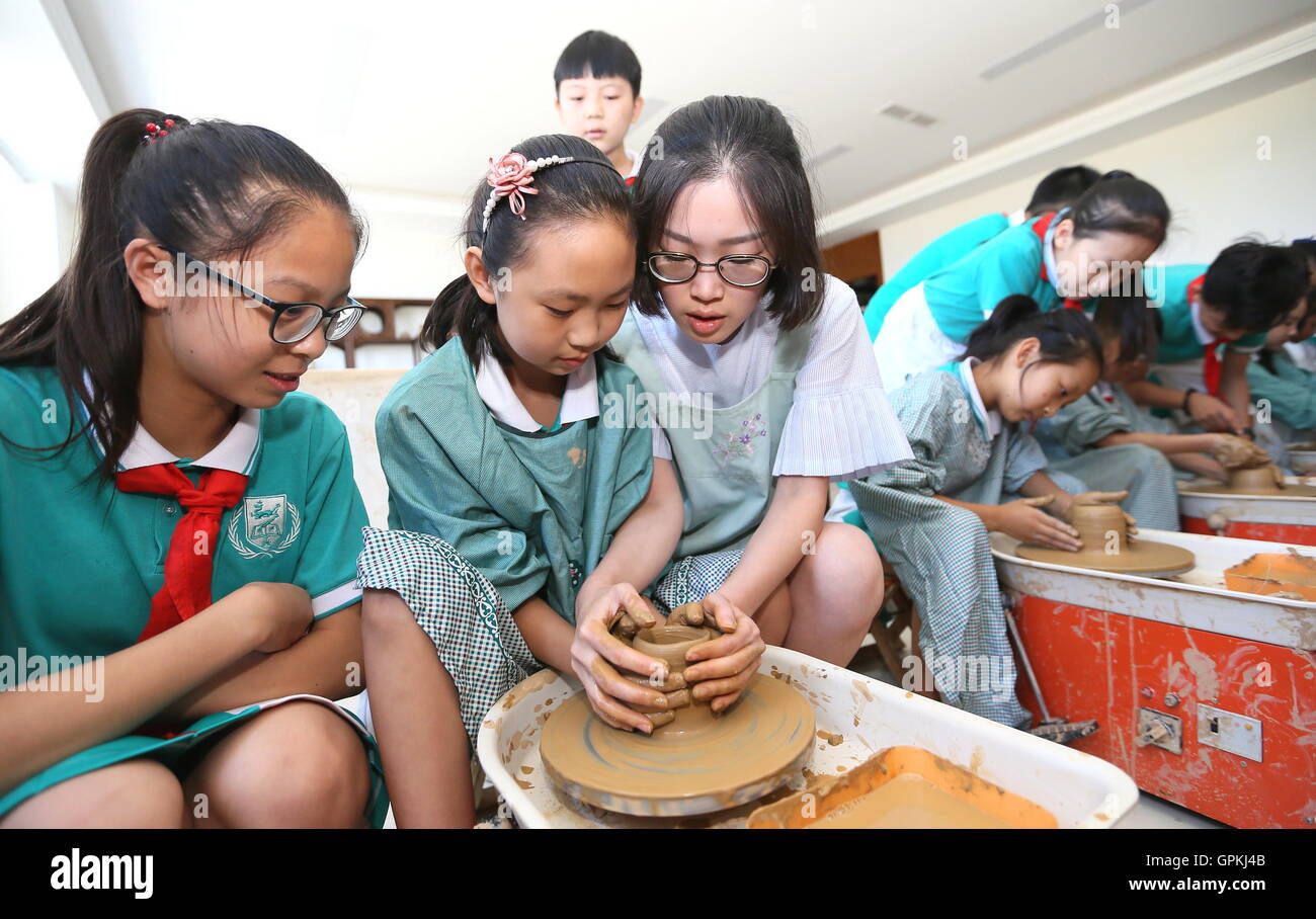 (160905) --JIMO, Sept. 5, 2016 (Xinhua) -- Students experience pottery making at Tongji Experimental School in Jimo, east China's Shandong Province, on Sept. 5, 2016. This school opened over 20 extra curriculums on robotic soccer, model airplane, opera mask painting, fencing, etc to enrich students' campus life. (Xinhua/Liang Xiaopeng) (wf) Stock Photo