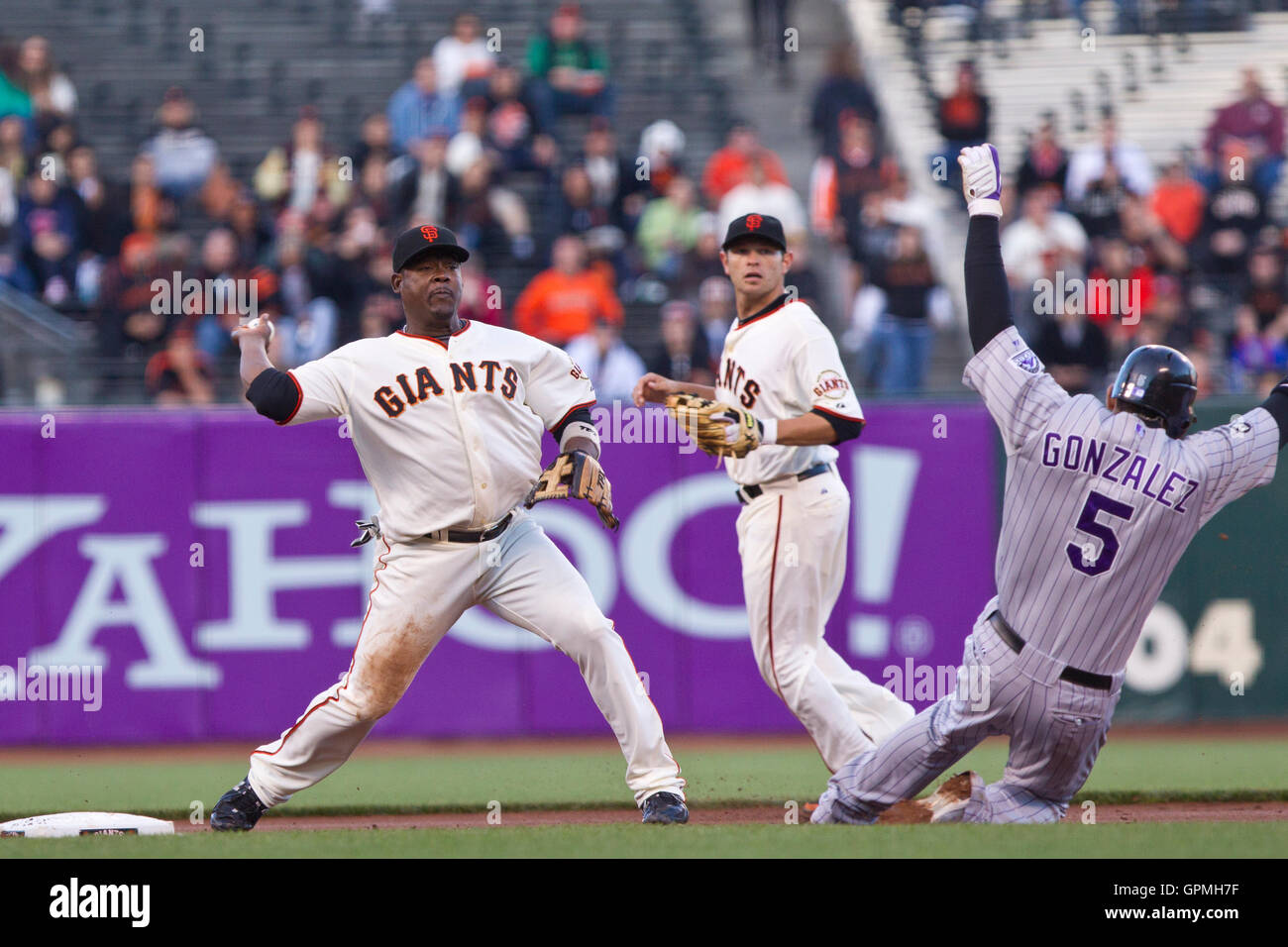 June 1, 2010; San Francisco, CA, USA;  Colorado Rockies center fielder Carlos Gonzalez (right) breaks up a double play as San Francisco Giants shortstop Juan Uribe (5) throws to first base during the first inning at AT&T Park. Stock Photo