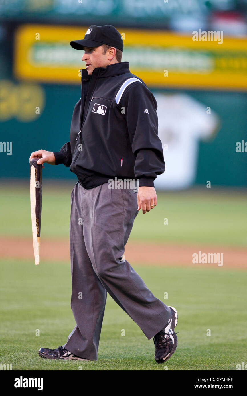 June 21, 2010; Oakland, CA, USA;  First base umpire Chris Guccione (68) recovers a broken bat during the second inning of the game between the Cincinnati Reds and the Oakland Athletics at Oakland-Alameda County Coliseum.  Cincinnati defeated Oakland 6-4 i Stock Photo