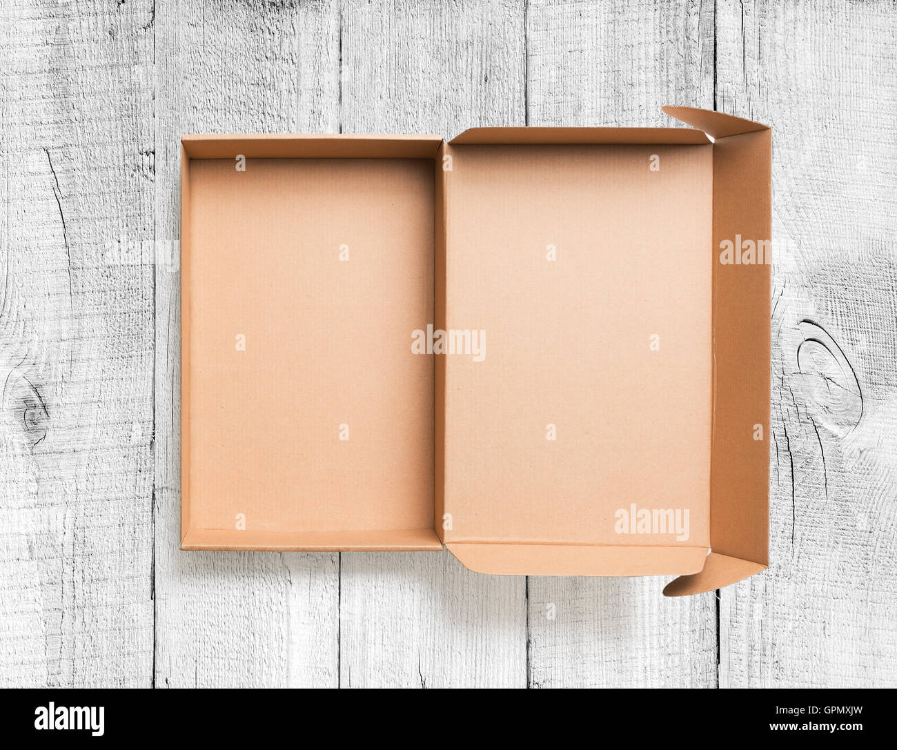 Open cardboard box top view on wooden background Stock Photo