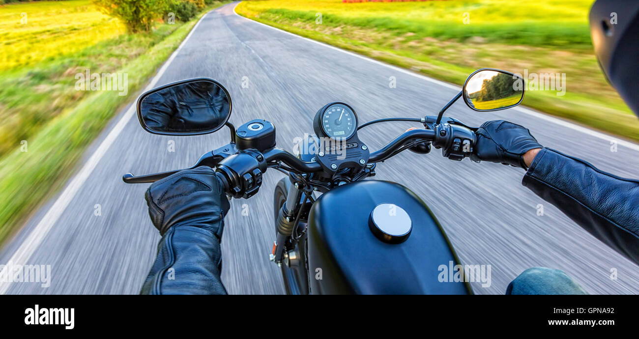 Motorcycle driver riding on motorway in beautiful sunset light. Shot ...